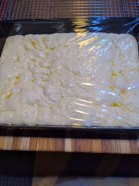 After rising for over 3 hours, the dough has bubbles on the surface.