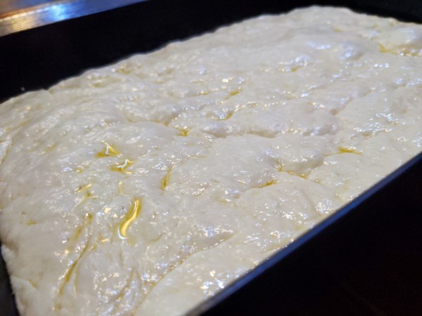 A close up, oblique view of the dough, showing the bubbles, nooks, and crannies developed over the last few hours of rising.