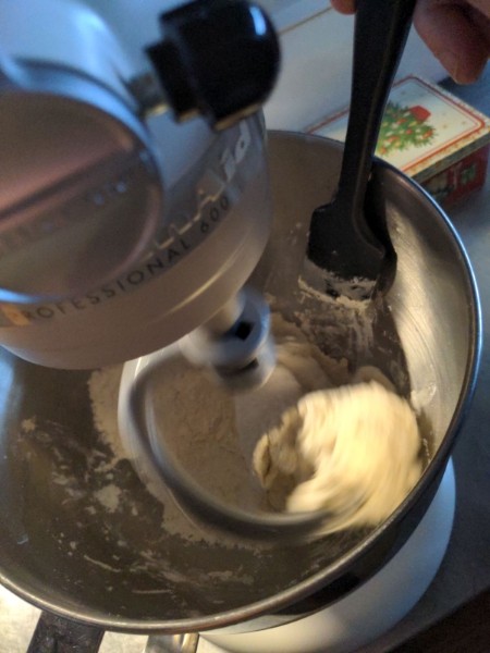 A flat silicone spatula is used to encourage the flour and water to make dough.