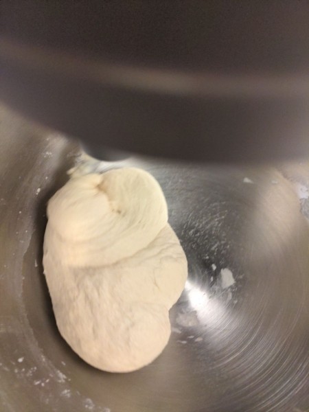 The dough ball in the bottom of the mixer looks smooth, and the bottom and sides are mostly clear. I could let it go longer until they were all the way clear, but it was good enough.